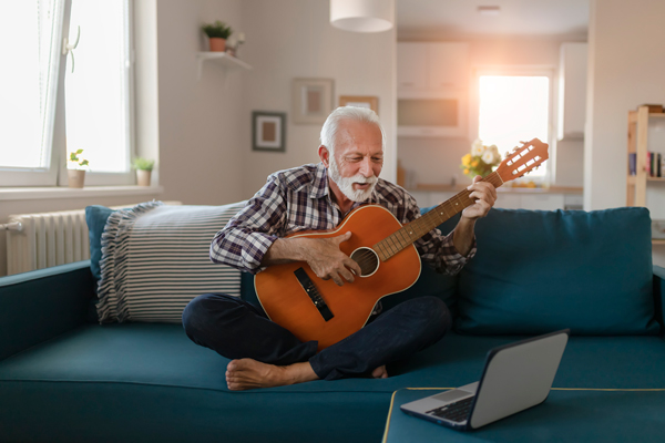 Retired-Man-Playing-His-Guitar-in-his-Indpenedent-Living-Apartment